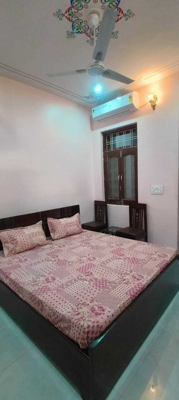 Traditional bedroom with wooden double bed, cushioned window seating, marble flooring, and decorative ceiling design